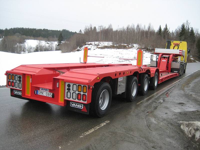 A low loader trailer carrying heavy equipment
